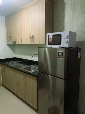a kitchen with a microwave on top of a refrigerator at condo near MOA&NAIA&Bay, full length mirror&balcony in Manila