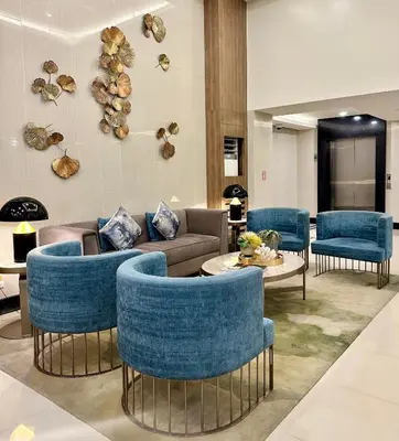 a lobby with blue chairs and a couch and a table at 2BR ManilaBay 180 Seaview Beside Okada 14 in Manila
