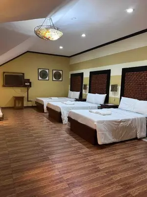 a hotel room with two beds and a flat screen tv at La Traviesa Hotel Resort in General Trias