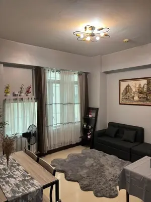 a living room with a couch and a table at Mariz Suites in Manila