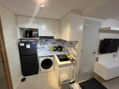 a small kitchen with a black refrigerator and a dishwasher at Enzo vibes bnb in Manila