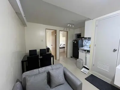 a living room with a couch and a kitchen at Enzo vibes bnb in Manila