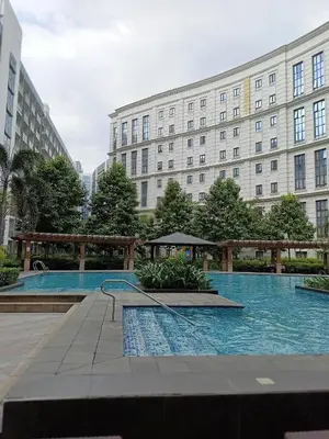 a swimming pool in front of a large building at Dreamy Condotel Across NAIA Terminal 3 in Manila