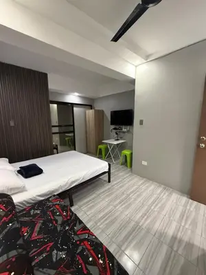 a hotel room with a bed and a desk at Studio Room near Circuit Makati in Manila
