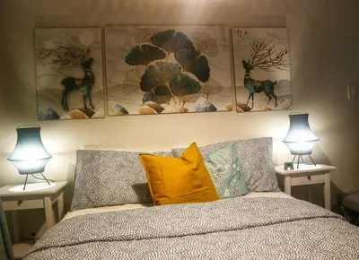 a bedroom with a bed with three pictures on the wall at Calming Haven at City Center with Netflix and Hi-Speed Wi-Fi in Manila