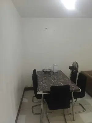 a dining room table with black chairs in a room at Chateau Elysee in Manila