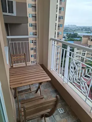 a wooden bench and a chair on a balcony at Comfortable 3-Bedroom Stay in Pasig The Rochester in Manila