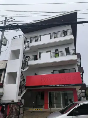 a white building with a red sign on it at Yujia Apartment in Manila