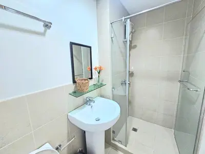 a bathroom with a sink and a glass shower at The Infinity Towers in BGC - Spacious 2 Bedroom - View, Washer, Fast WiFi in Manila