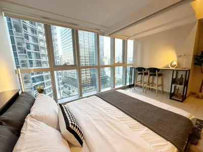 a bedroom with a bed and a large window at BGC 1BR with Fast wifi and Pool use in Manila