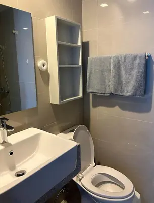 a bathroom with a sink and a toilet and a mirror at BGC 1BR with Fast wifi and Pool use in Manila