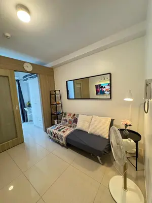 a bedroom with a bed and a tv on the wall at MOA Staycation at Shore Residences Tower C in Manila