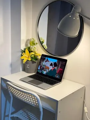 a laptop on a desk with a lamp and a mirror at MOA Staycation at Shore Residences Tower C in Manila