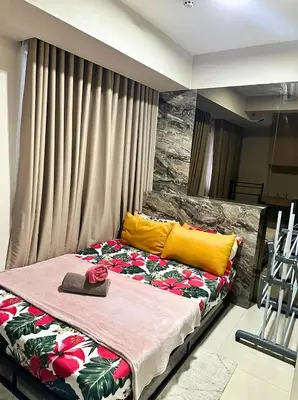 a bedroom with a large bed with flowers on it at One-bedroom condo within the city at S Residences in Manila