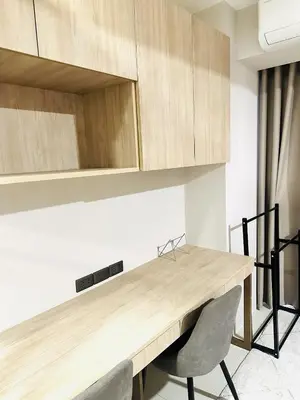 a kitchen with a wooden table and two chairs at One-bedroom condo within the city at S Residences in Manila