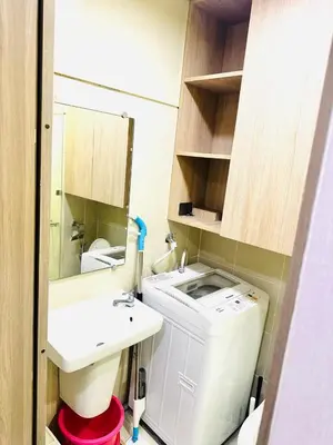 a bathroom with a sink and a toilet and a mirror at One-bedroom condo within the city at S Residences in Manila