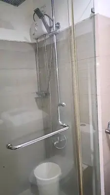 a shower stall with a toilet in a bathroom at Pool view from one-bedroom condo at Shore Residence in Manila