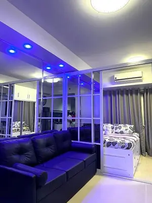 a living room with a couch and a bed at One-bedroom condo at Shell Residences in Manila