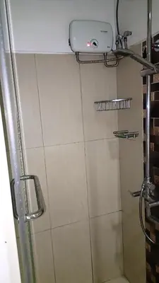 a bathroom with a shower with a camera on the wall at One-bedroom condo at Shell Residences in Manila