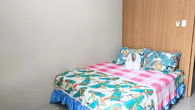 a bedroom with a bed with a colorful blanket at Spacious simple one-bedroom condo at Shell Residence in Manila