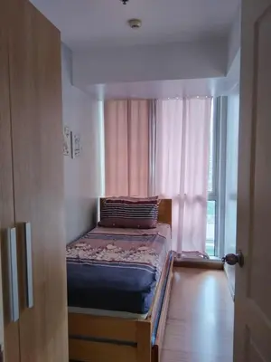 a small bed in a room with a window at Azure Urban Resort Residences in Manila