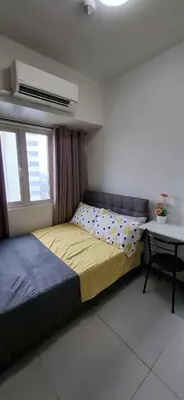 a bedroom with a bed and a table in it at Cozy 1 Bedroom unit in Manila in Manila