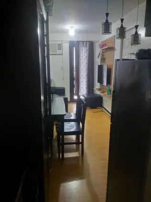 a living room with a table and chairs and a kitchen at May homey vibe in Pasig