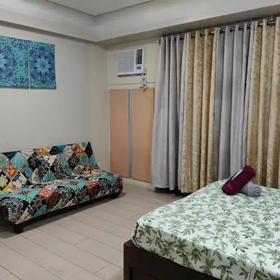a bedroom with a bed and a couch and curtains at LDN Secret Crib 5K- Two Palm Tree in Manila