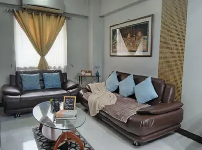 a living room with a leather couch and a glass table at Cheap Accommodation - Newport Boulevard in Manila