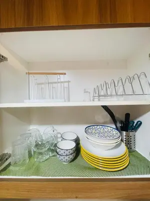 a shelf with plates and bowls in a kitchen at Luna Suite in Manila