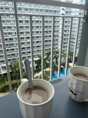 two cups of coffee sitting on a table with a window at Dona staycation in Manila