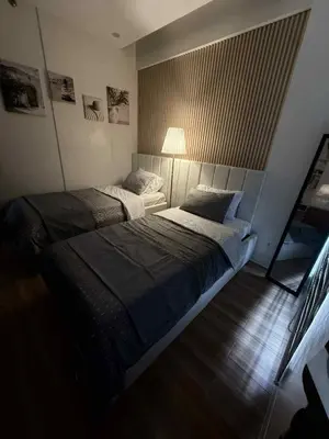 a bedroom with two beds and a lamp at Miyu's Staycation Place in Biñan
