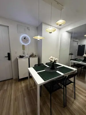 a room with a table and chairs and a kitchen at Miyu's Staycation Place in Biñan