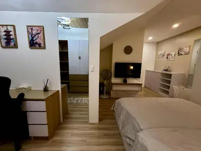 a bedroom with a bed and a desk and a television at Miyu's Staycation Place in Biñan