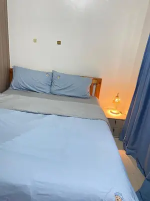 a bedroom with a bed with blue pillows at SHORE 2 tower 2 in Manila