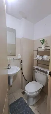 a bathroom with a white toilet and a sink at Soap's Haven Rental Unit in Paranaque in Manila
