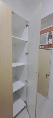 a walk in closet with white shelves and a door at Soap's Haven Rental Unit in Paranaque in Manila