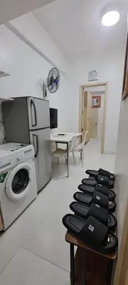 a kitchen with a washing machine and a table at Soap's Haven Rental Unit in Paranaque in Manila