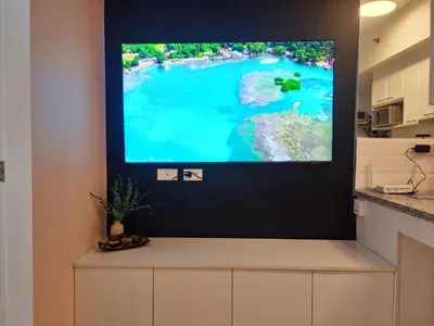 a flat screen tv hanging on a wall in a kitchen at Modern Bright Cozy Stylish 1BR Venice BGC Balcony in Manila