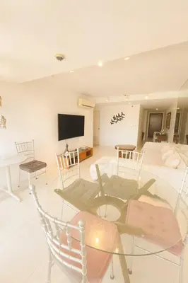a living room with a glass table and a tv at Cozy & Spacious 2BR Stay Near BGC - Home Theater in Manila
