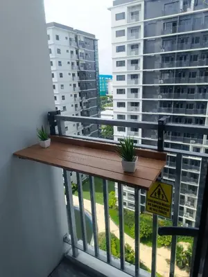 a balcony with a wooden railing with two plants on it at SkyShore Suites in Manila