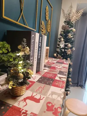 two christmas trees on a table next to books at SkyShore Suites in Manila