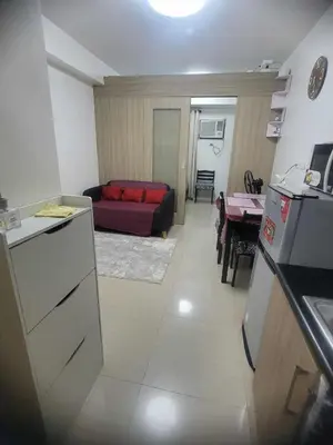 a kitchen and a living room with a couch at Apartment Condo Unit 1-br Self-contained in Manila