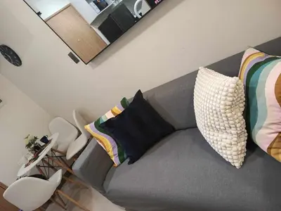 a living room with a gray couch with pillows at Brand New 2 Bedder near Malls SMDC Bloom in Manila