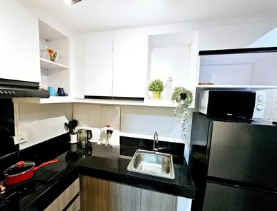 a kitchen with a sink and a black refrigerator at Brand New 2 Bedder near Malls SMDC Bloom in Manila