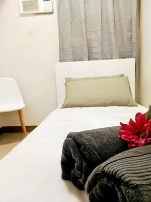 a bedroom with a white bed with a red flower on it at Brand New 2 Bedder near Malls SMDC Bloom in Manila