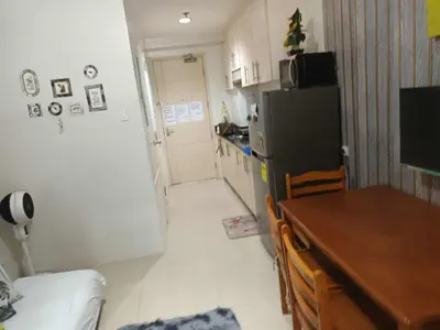 a small kitchen with a table and a refrigerator at Sea residence MOA KC PLACE in Manila