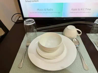 a table with a plate and a cup and spoon and fork at Pocco-breeze- inhouse pool in Manila