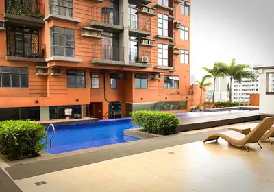 a building with a swimming pool in front of a building at Dibuho Studio in Manila