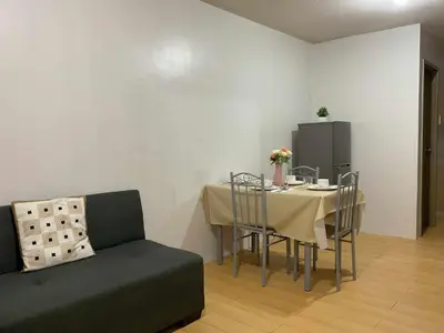 a living room with a table and a couch at DBK HOMES Sorrento Oasis in Manila
